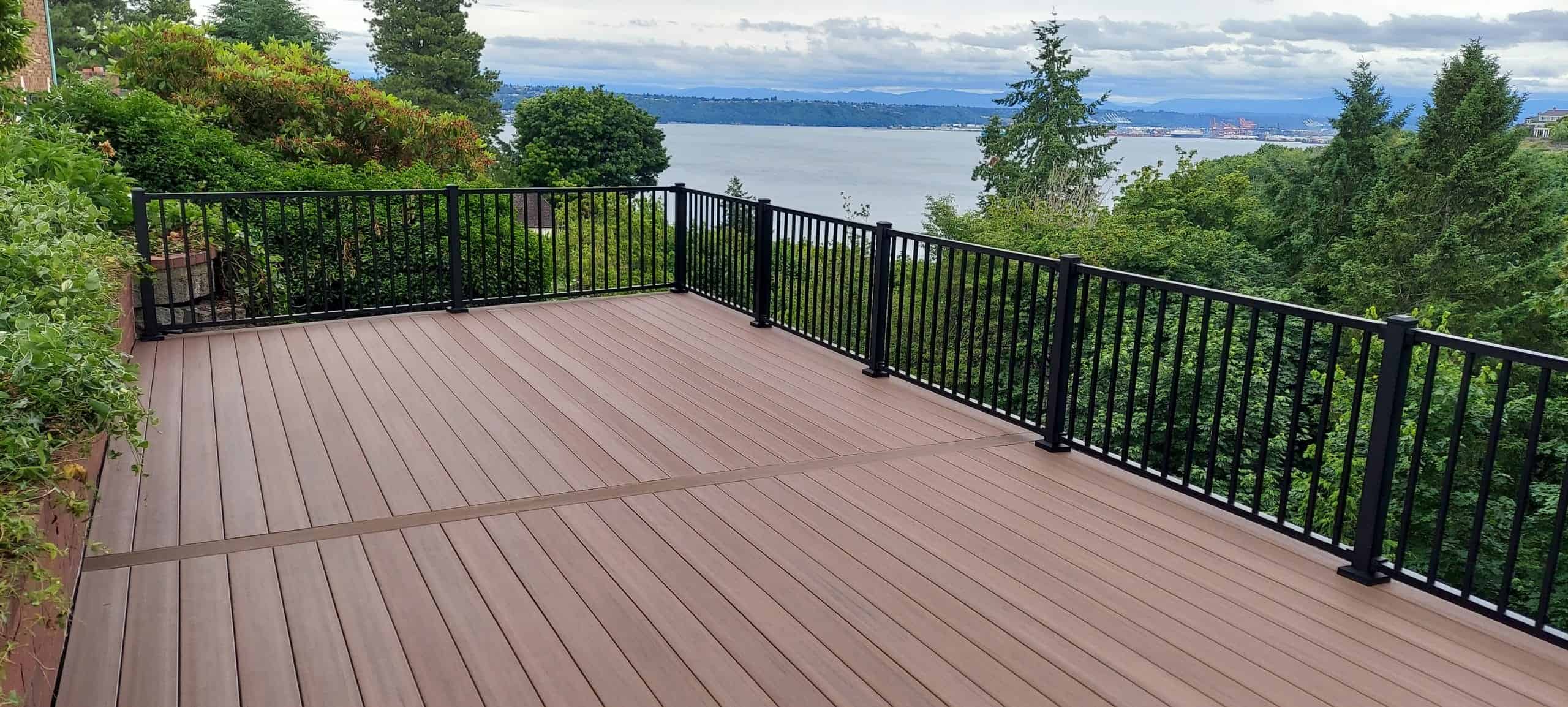 Composite deck with black metal railings overlooking Commencement Bay and the Tacoma waterfront — Father Nature outdoor carpentry