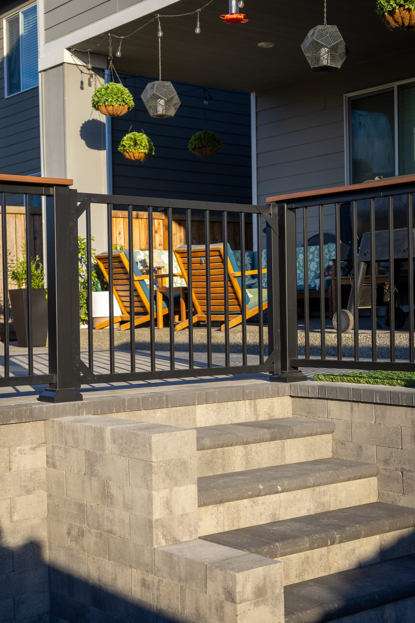 A close view of the Charcoal Black TimberTech aluminum railing running along the top of a stone retaining wall