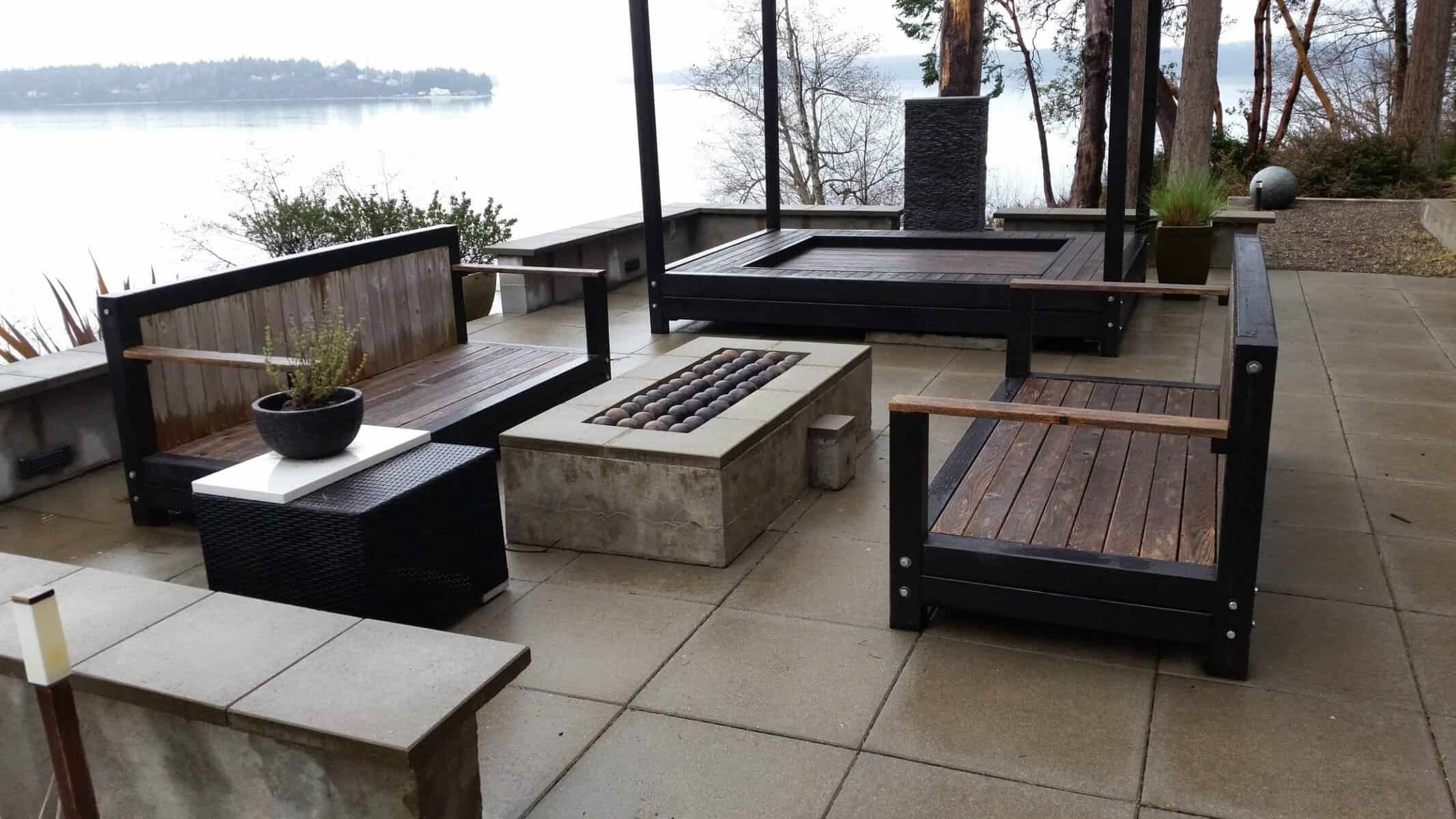 Board-formed concrete shoreline backyard with outdoor living built by Father Nature Landscapes