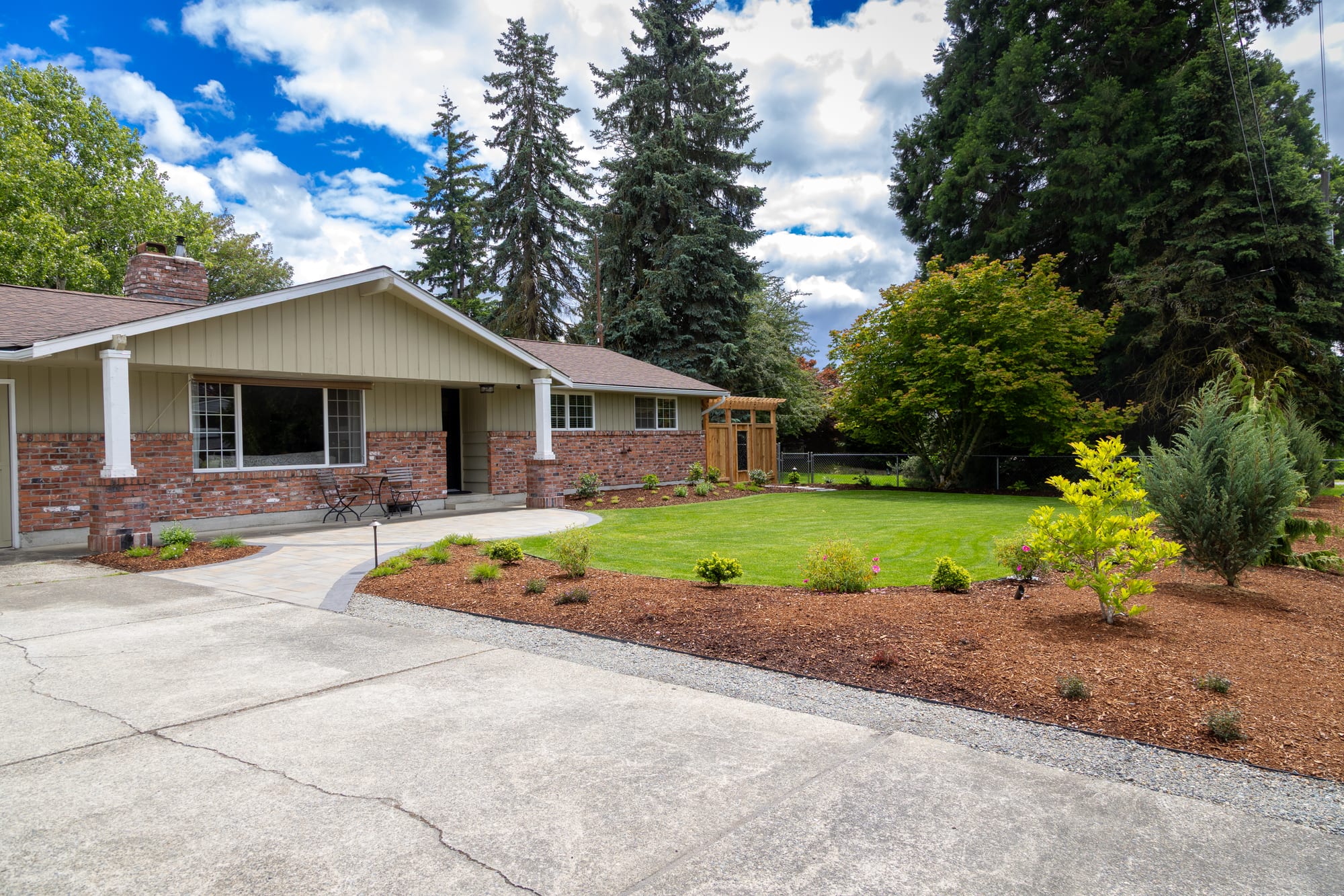 Renovated Tacoma front yard with new lawn, fresh planting beds, and a paver driveway