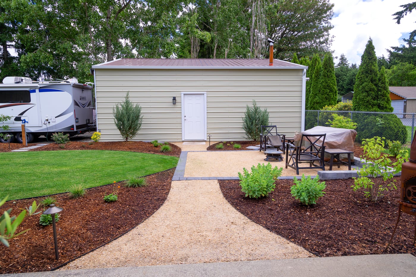 A compacted gravel pathway and seating area in the backyard
